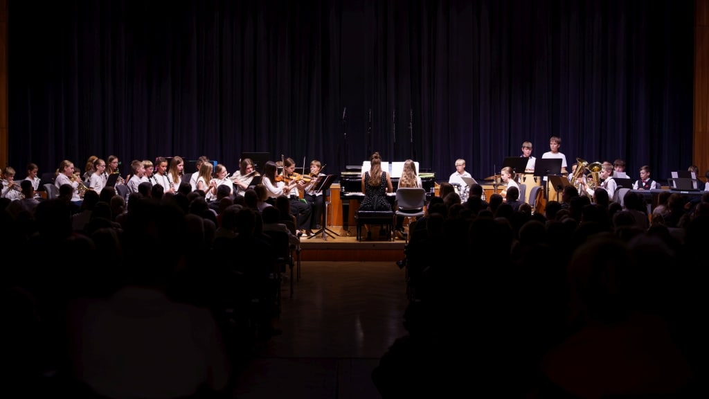 Schulorchester-Konzert Schulorchester-Auftritt auf der Bühne mit Schülern und Publikum